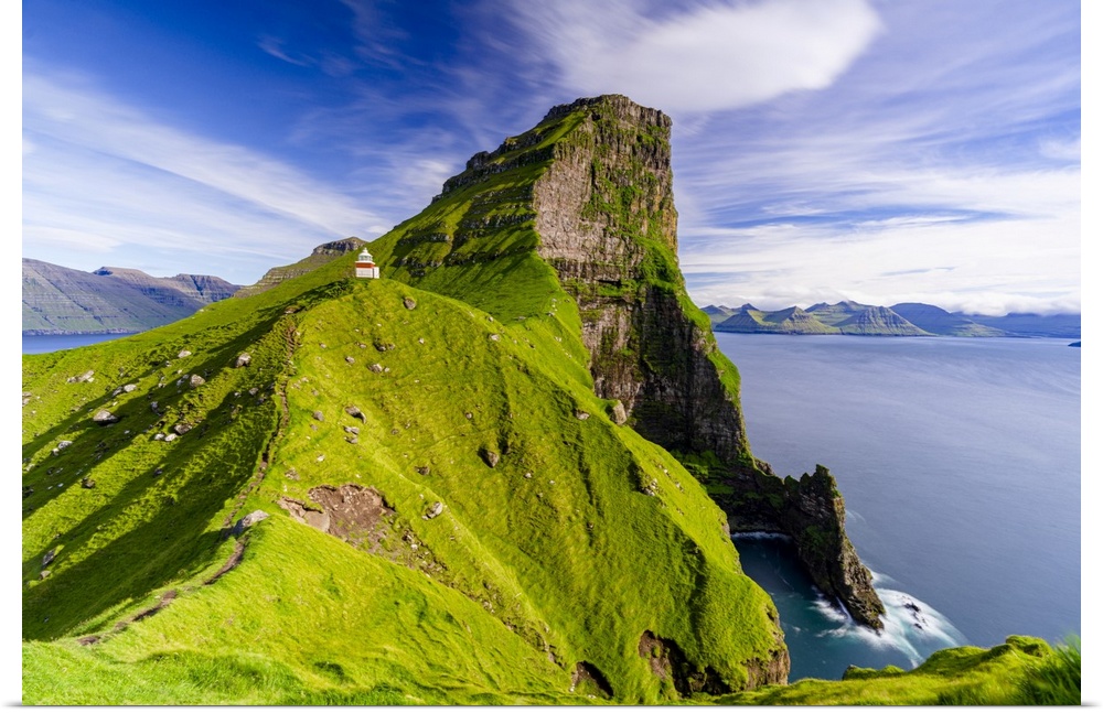 Kallur lighthouse on cliffs covered with grass with Borgarin mountain peak on background, Kalsoy island, Faroe Islands, De...