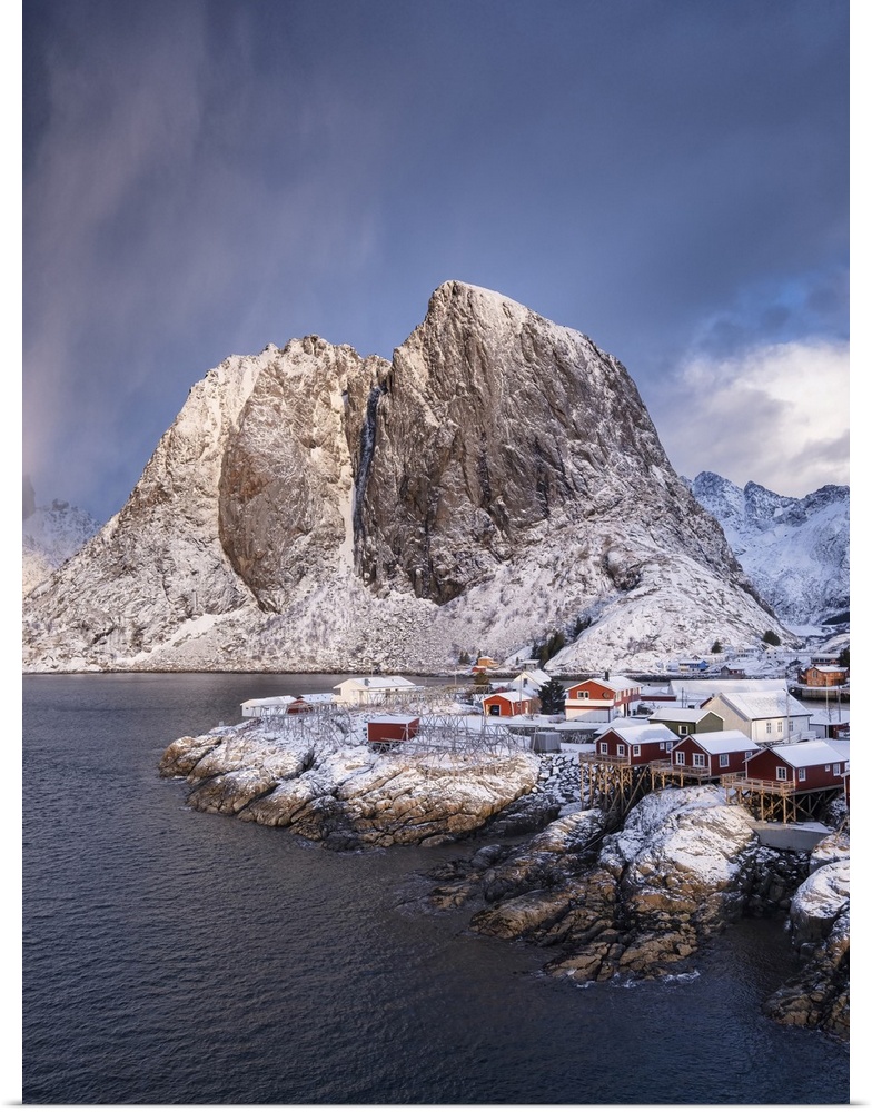 Red Norwegian Rorbuer Huts and Festhaeltinden mountain in winter, Hamnoy, Moskenes Municipality, Nordland County, Lofoten ...