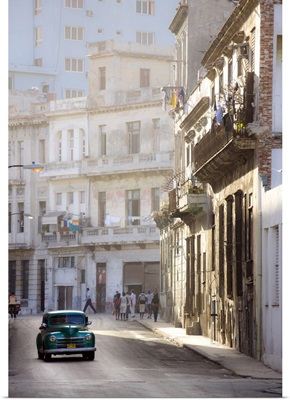 Old American car driving along quiet street in Havana Centro, Havana, Cuba, West Indies