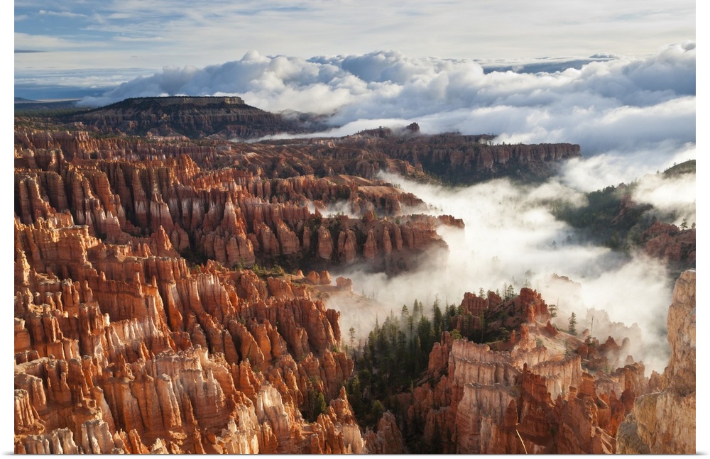 Pinnacles and hoodoos with fog extending into clouds of a partial temperature inversion, Bryce Canyon National Park, Utah,...
