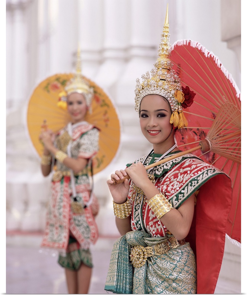 Portrait of two dancers in traditional Thai classical dance costume, smiling and looking at the camera, Bangkok, Thailand,...