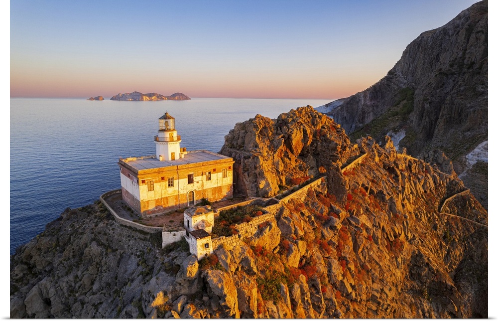 Aerial view of Punta della Guardia lighthouse on top of a cliff on the island of Ponza, lit from sunrise, Ponza island, Po...