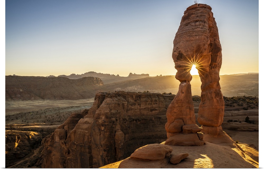 Setting sun through Delicate Arch with sunburst, Arches National Park, Utah, United States of America, North America