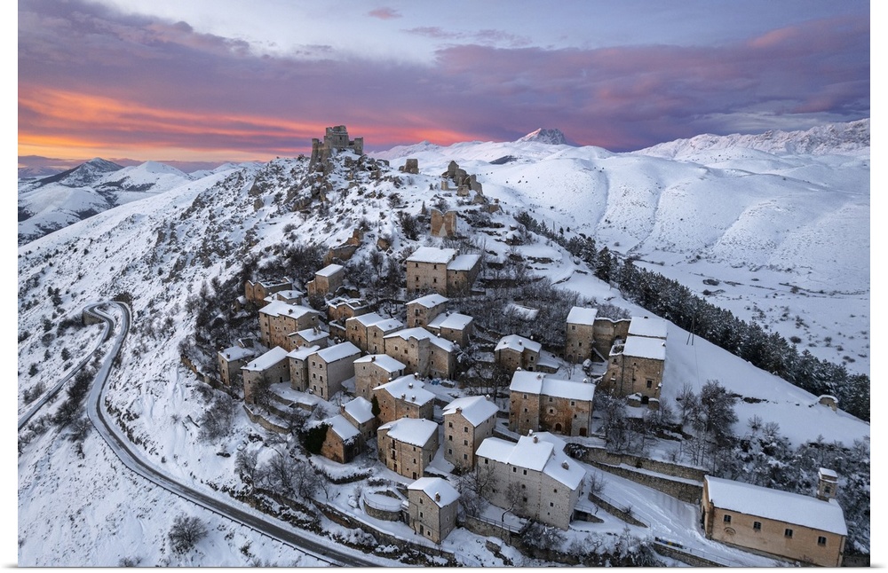 Aerial winter view of the snow covered medieval village of Rocca Calascio with the castle and pink clouds at dusk, Rocca C...