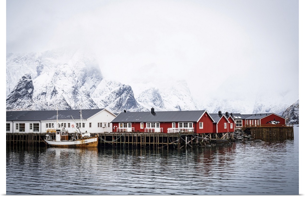 Foggy sky over snowcapped mountains and traditional Rorbu cabins by the sea, Hamnoy, Nordland county, Lofoten Islands, Nor...