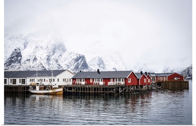 Snowcapped Mountains And Traditional Rorbu Cabins, Lofoten Islands, Norway