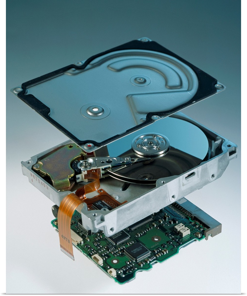 Computer hard disk assembly. Component parts of a hard disk showing the outer aluminium casing (top), the hard disk platte...