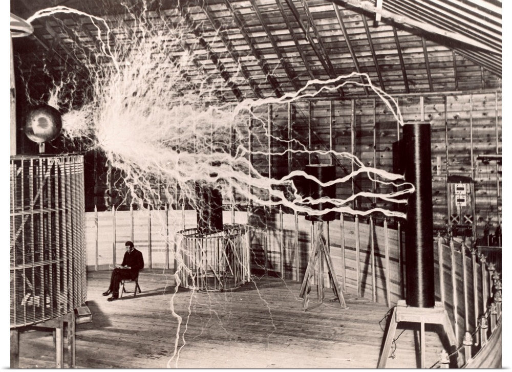 Tesla coil experiment. Electrical streamers sparking outwards from a large Tesla coil at left to another one at right, at ...