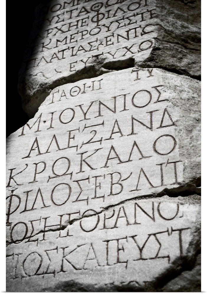 Black and white photograph taken of ancient text carved into a stone wall.
