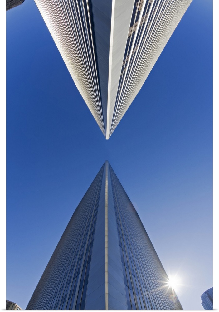 Photograph of two skyscrapers from below looking up.