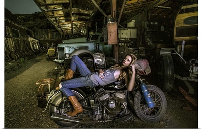 Blonde girl laying on an old Harley Davidson