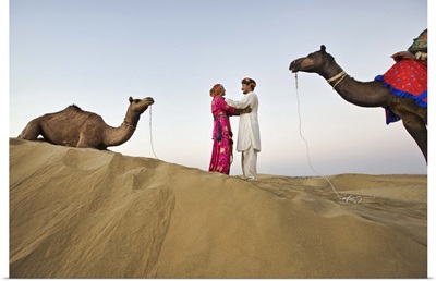 Bride and groom with camels in sand dunes, Rajistan, India