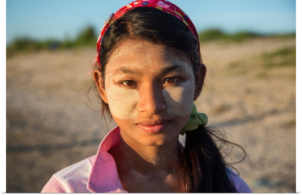 Burmese girl with facepaint at sunrise, Mandalay, Burma.