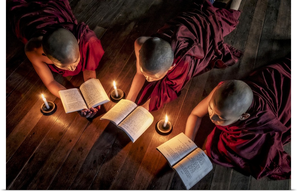 Burmese monks reading by candlelight in their monastery
