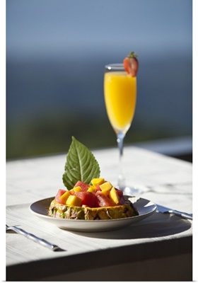 Fruit and a mimosa in a restaurant with a view of the ocean
