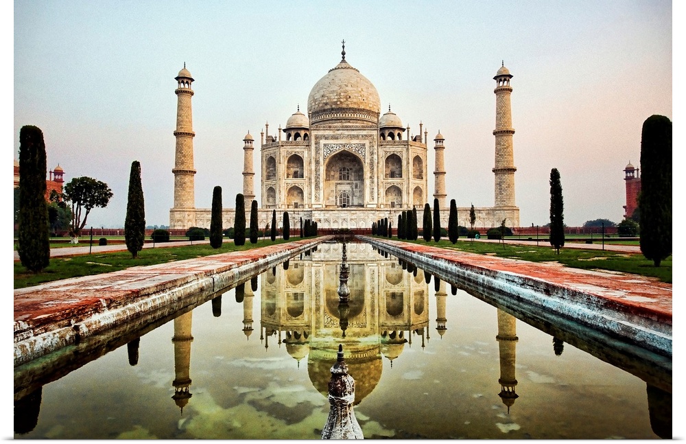 Photograph of an ornate marble mausoleum.  A reflection pool is located in front lined with tall shaped trees.