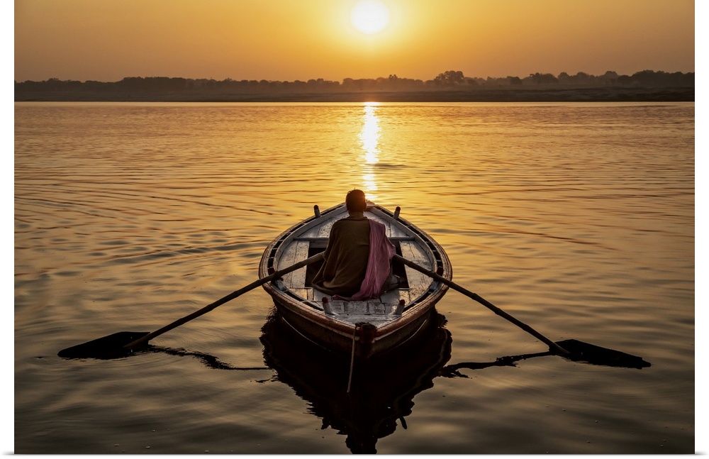 Man rowing a longtail boat on the Ganges River, Varinasi, India