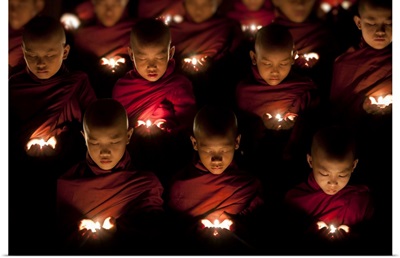 Monk boys praying by candle light in their monastery, Yangon, Burma