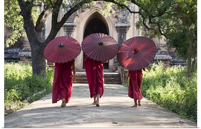 monks walking with parasols in monastery, Bagan, Burma