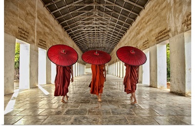 monks walking with parasols in monastery, Mandalay, Burma