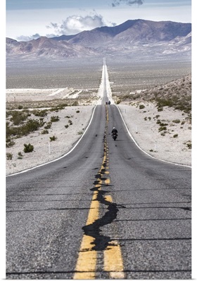 Motorcycles riding long road into Death Valley National Park
