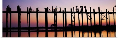 People walking across the UBein bridge at sunset in Mandalay