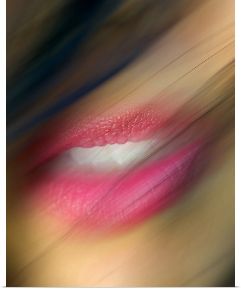Hair blows in front of a woman's lips that are photographed closely and appear slight blurry.