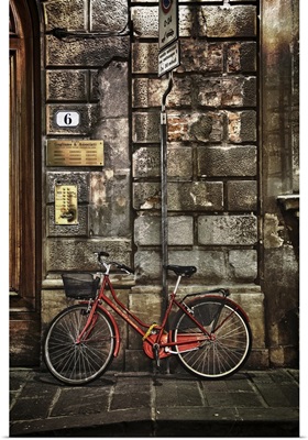Red bicycle by stone wall, Florence, Italy