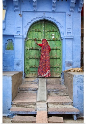 Woman knocking on door in the Blue City of Jodphur, India