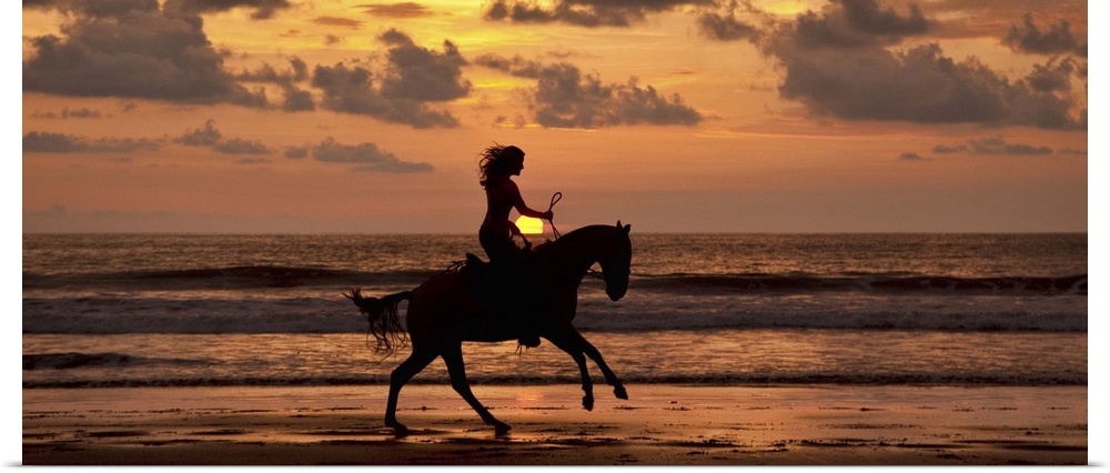 Woman riding a horse on the beach at sunset in Costa Rica