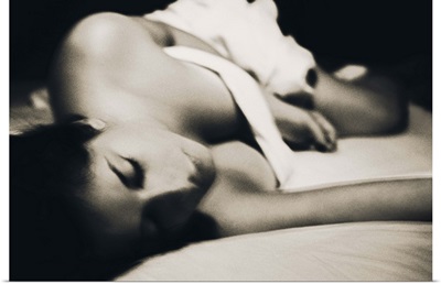 Woman under the sheets in bed, black and white photograph