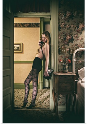 Woman wearing stockings and talking on the telephone in her hotel bedroom