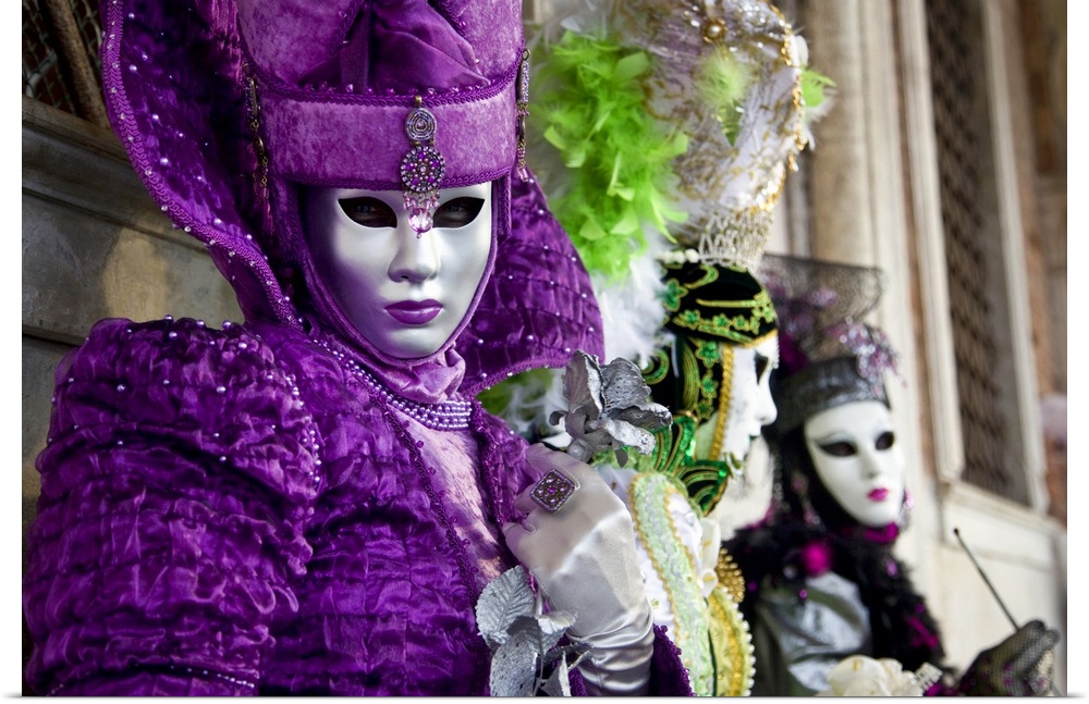 Women in masks and colorful costumes are photographed during a festival in Italy.
