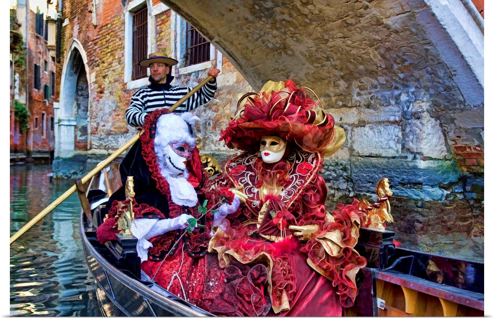 Women in masquerade outfits on a gondola at Carnival in Venice, Italy