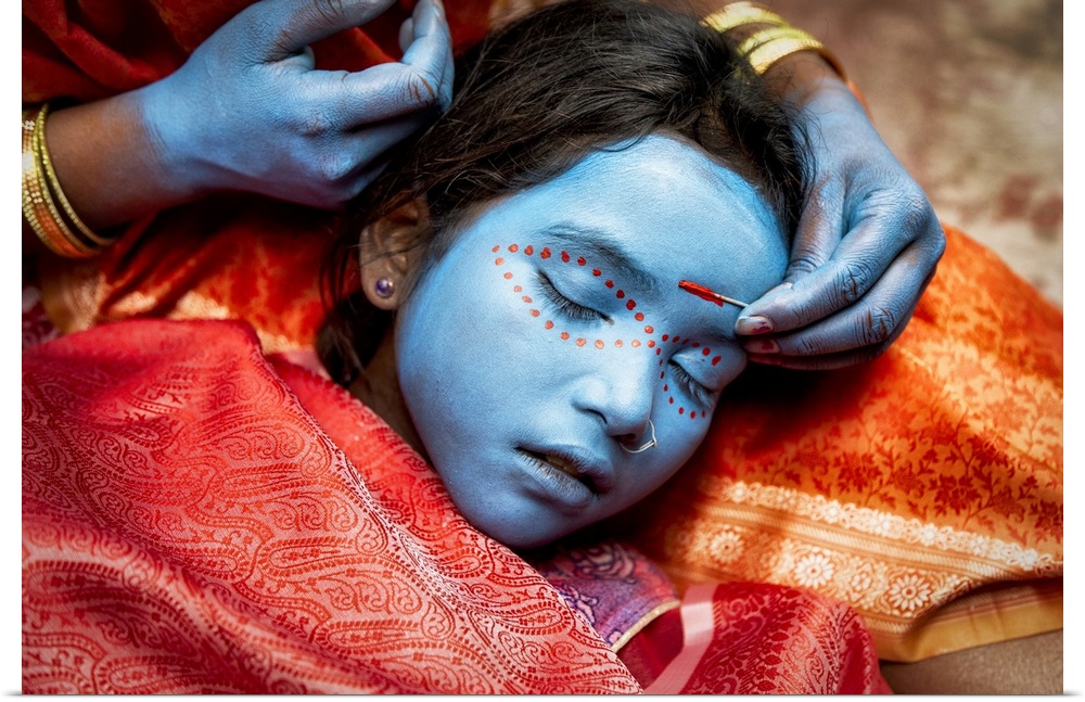 Young girl having her face painted in Varinasi, India