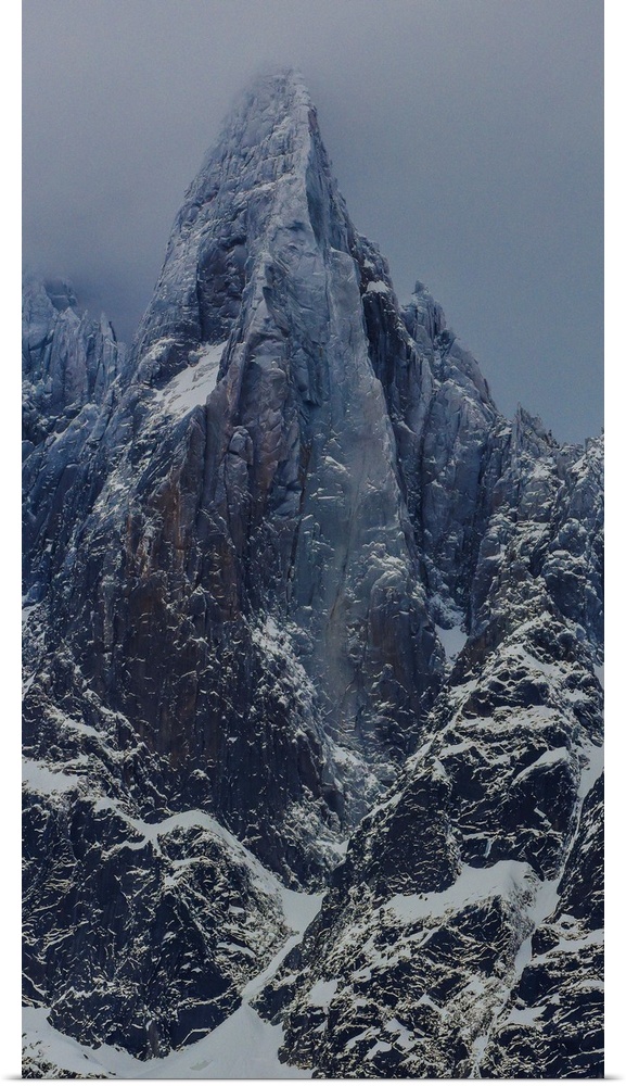 Landscape photograph of the Aiguille du Dru in the Alps with a grey sky.