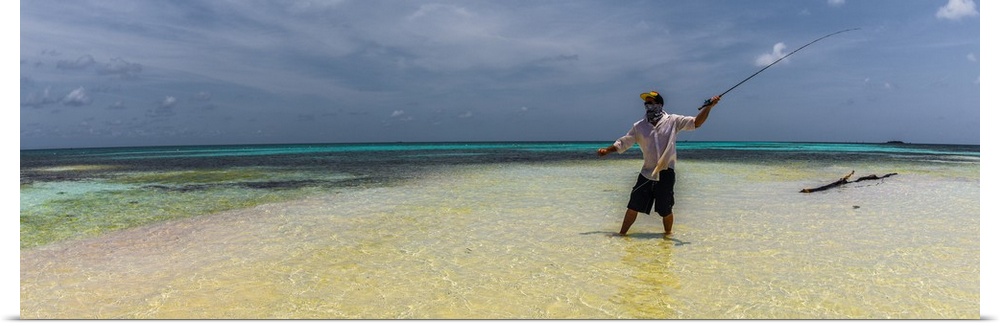 A man fly fishing in the ocean on a tropical beach in Belize, 2016.