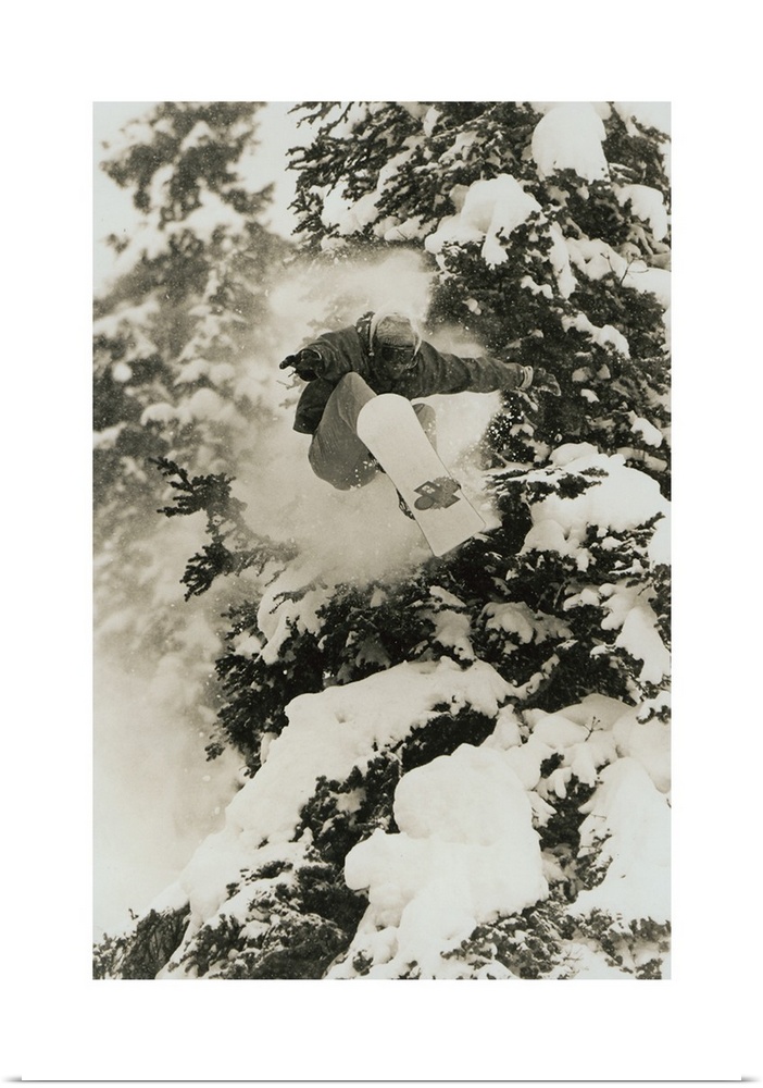 Photograph of Marc Morriset snowboarding over snow covered trees in the Selkirk Mountains, British Columbia, Canada