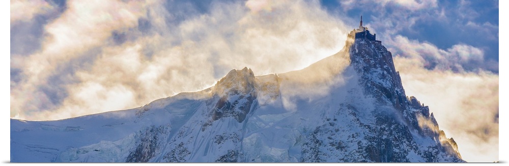 Photograph of Mont Blanc surrounded by sunlit clouds.