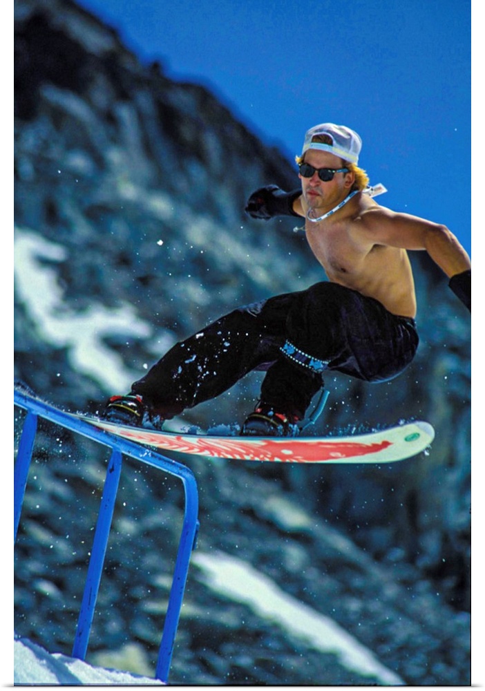 Vintage photo of Jeff Brushie as he tailslides a rail on the Blackcomb glacier. Photo may have a film grain texture. Locat...