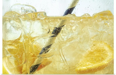Close Up Of Lemon Slices In Stirring The Lemonade And Ice Cubes, Bubbles Fizzing
