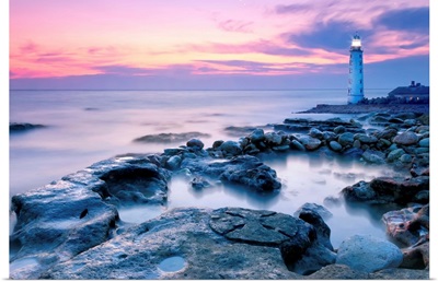 Lighthouse On Rocky Coastline At Sunset