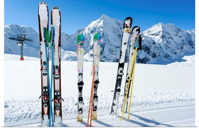 Skis sticking in the snow on a mountain slope.