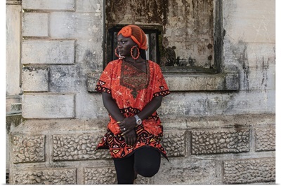 Woman Stands By Old Building With Traditional Orange African Dress, Takoradi, Ghana