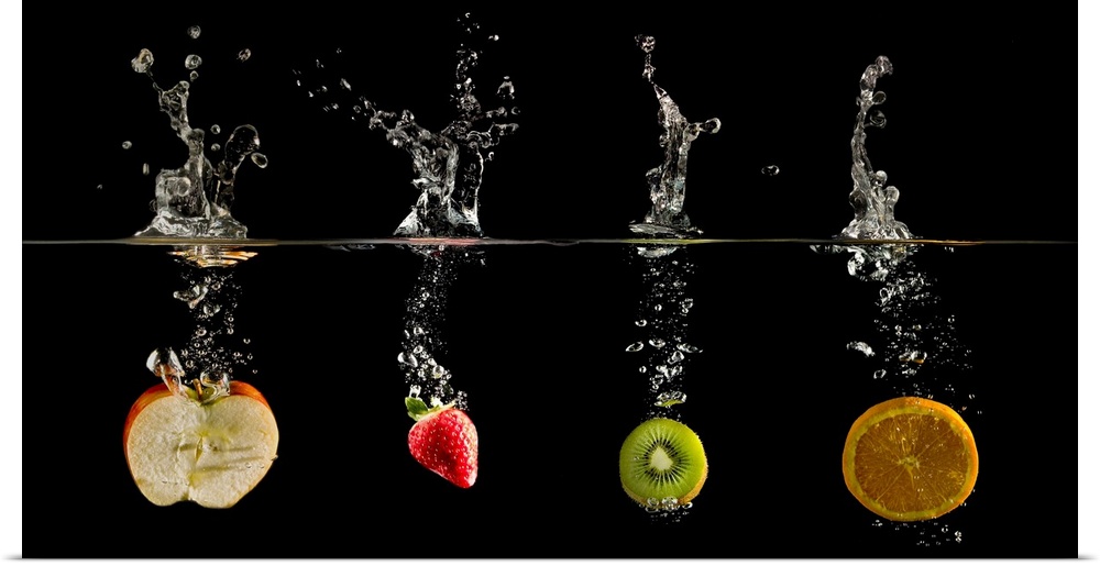 Fruit dropped into water creating a glass like water splash and bubbles.