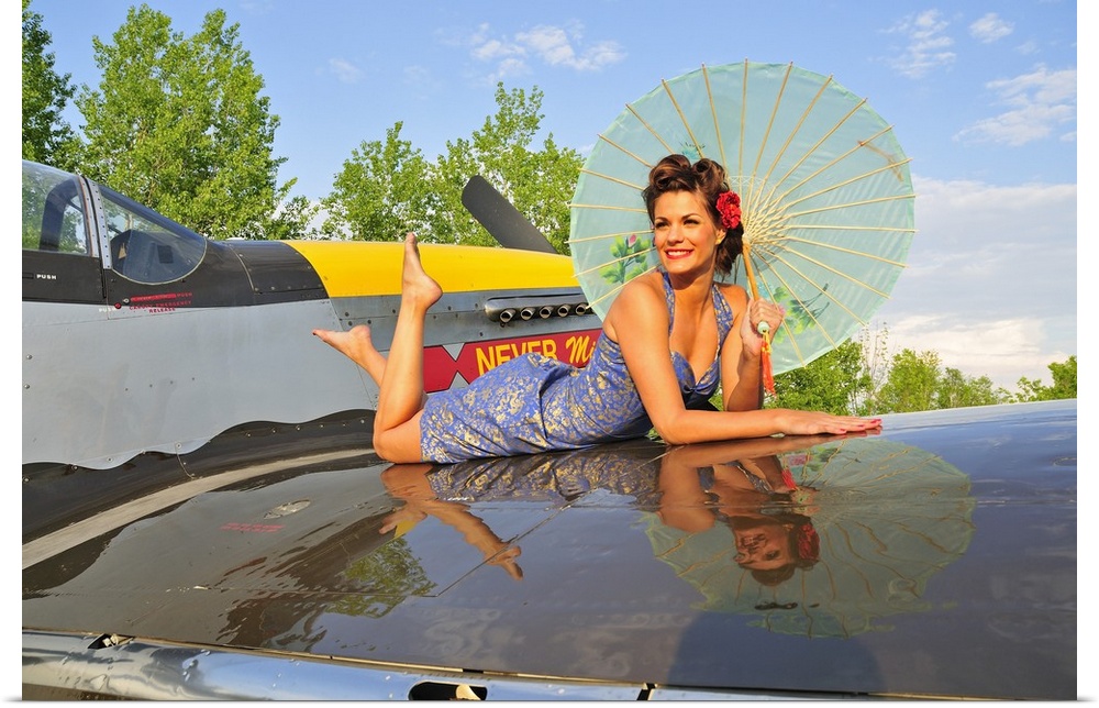 Beautiful 1940's style pin-up girl with parasol on a vintage P-51 Mustang.