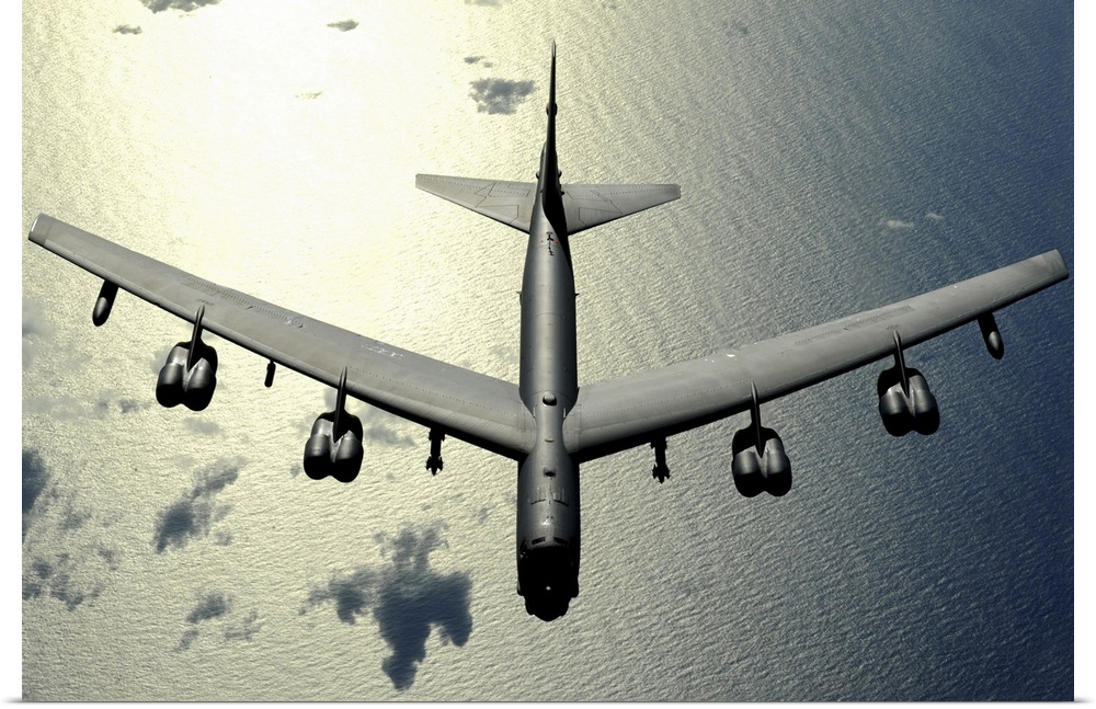 Horizontal aerial photograph on a  big wall hanging, looking down at the top of a B52 Stratofortress  as it flies over the...
