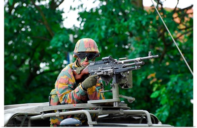 A Belgian Army soldier handling a machine gun atop a Unimog vehicle