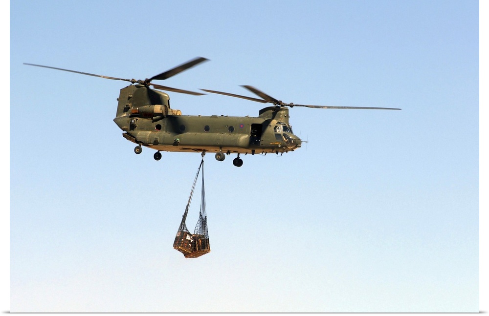A CH-47 Chinook of the Royal Air Force transports a sling load of pallets.