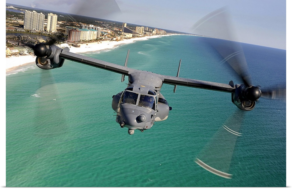 Large landscape photograph of a CV22 Osprey aircraft flying toward the camera, over the green and blue waters of the Emera...